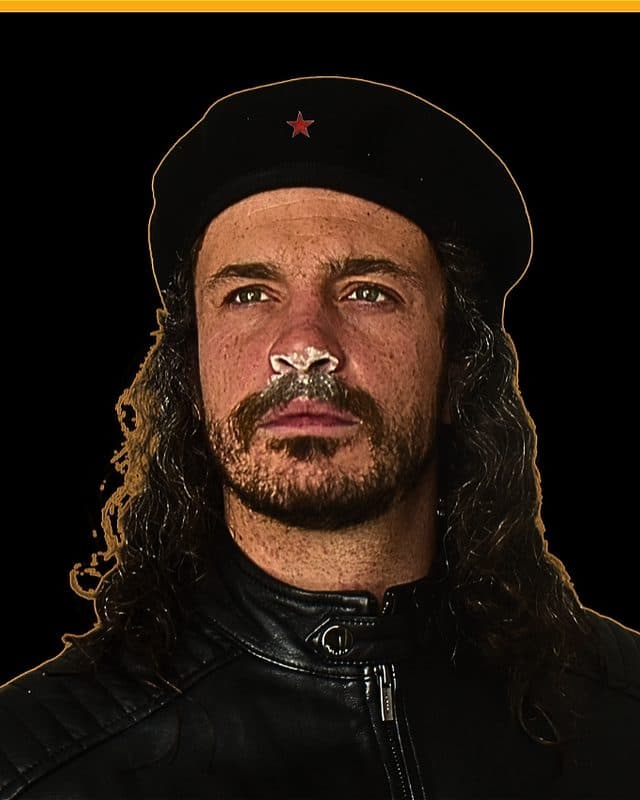 The image portrays Iain Pringle as the marxist revolutionary Che Guevara (black beret with a central red star and a black jacket) with white powder dusted on his nostrils. The image is superimposed on a plain black background with a yellow border.