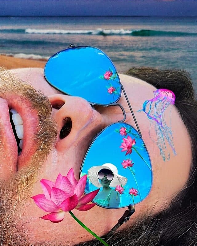 A man in repose wears sunglasses reflecting the image of a woman wearing a white hat with a wide, undulating brim. Superimposed across the man's face and glasses are a trail of bright pink lotus flowers, the petals and stems of which evoke the fronds and trunks of a palm tree colonnade. A bright pink and turquoise jellyfish lays across the sandlike expanse of the man's forehead, as though it had been left behind after the retreat of a recent tropical wave.